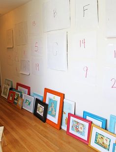 there are many frames on the wall with numbers and letters written on them in different colors