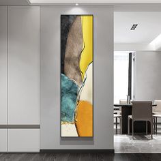 an abstract painting hangs on the wall next to a dining room table