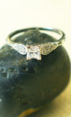 a diamond ring sitting on top of a rock