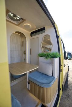 the interior of an rv with a table and chairs in it, as seen from the rear door