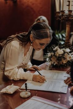 a bride signing her marriage vows at the table