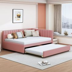 a living room with a pink couch and ottoman