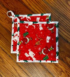 two red and white christmas napkins sitting on top of a wooden floor