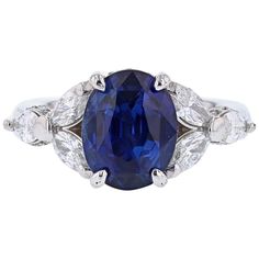 This ring is made in Platinum and features one GRS certified Oval Cut, Natural Blue Sapphire weighing 5.01ct, prong set, originating from Sri Lanka. The GRS report number is GRS2014-077118. The ring also has a features 6 Marquise cut diamonds weighing 1.04cts and 40 round cut diamonds weighing 0.25cts with a color grade (H) clarity grade (SI2). Pear Sapphire Ring, Modern Diamond Jewelry, Royal Rings, Oval Cut Diamond Rings, Contemporary Engagement Rings, Cushion Cut Ring, Modern Engagement Rings, Blue Sapphire Ring, Three Stone Diamond