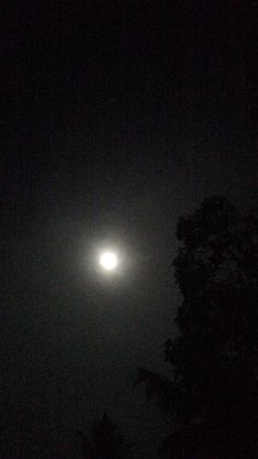 the moon is shining brightly in the dark sky