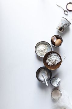 an assortment of ingredients are displayed on a white counter top with utensils and spoons