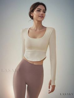 a woman in tight pants and crop top posing for the camera with her hands on her hips