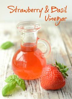 a bottle of strawberry and basil vinegar next to a strawberry