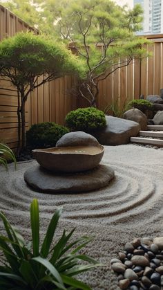 a garden with rocks and trees in the middle, surrounded by graveled steps leading up to a wooden fence