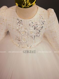 the back of a white dress with sequins and beads on it's neck