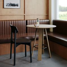 a table and two chairs in a room with wood paneling on the wall behind it