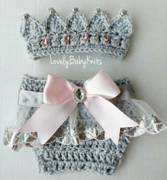 two crocheted crowns with pink bows on them