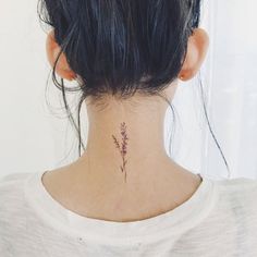 a woman with a tattoo on her neck and behind her head is a small flower