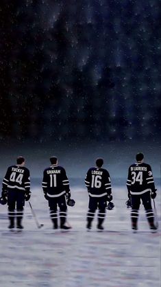 five hockey players are standing on the ice and waiting for their turn to play against each other