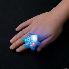 a child's hand with a glowing snowflake ring on it