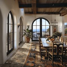 a dining room with an arched window overlooking the ocean