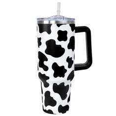 a black and white cow print travel mug with a straw sticking out of the lid