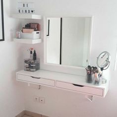 there is a white vanity with two drawers and a mirror on the wall above it