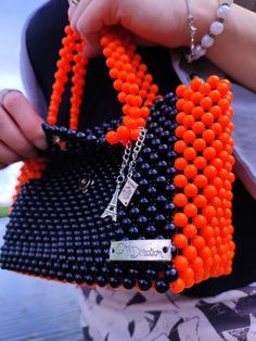 A bright and roomy daily handmade beaded handbag. This women's purse is large and holds everything you need, a mobile phone of any size, a small wallet, a power bank, a mirror, lipstick, keys, a bottle of your favorite perfume, and there is also room for trinkets. The bag is woven with black acrylic beads, while the sides, bottom and handles were woven with bright orange beads for accent.  The bag is lined and closes with a magnetic clasp. Also, the handbag is additionally decorated with small p Everyday Rectangular Shoulder Bag With Colorful Beads, Beaded Tote Shoulder Bag, Everyday Beaded Tote Shoulder Bag, Rectangular Beaded Bag For Daily Use, Beaded Tote Bag For Daily Use, Daily Use Beaded Tote Bag, Square Beaded Bag For Everyday Use, Handmade Orange Top Handle Shoulder Bag, Orange Handmade Top Handle Shoulder Bag