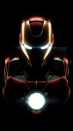 the iron man helmet is lit up in the dark with its light shining on it