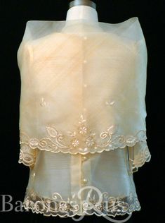 the back of a dress with white lace on it and an open collared top