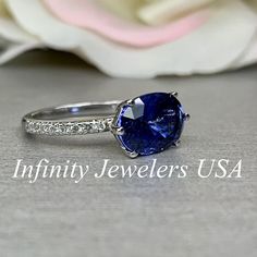 "The ring pictured is a lab created blue sapphire with genuine diamond accents #5931 This ring is also offered with Moissanite accents Use the drop down menu to make your selection -Approximate total carat weight: 3.15ctw diamond equivalent -Center Stone Size: 11x8mm - approx. 2.90ct diamond equivalent -Center Stone Shape: oval -Gem Type: lab created sapphire -Stone Clarity: VS2 -Stone Color: Blue -Moh's Scale: 9 hardness -Side Stones Size: 16 round - approx. 0.25ct. diamond equivalent -Gem Type Elongated Cushion Cut, Ceylon Blue Sapphire, Elongated Oval, Platinum Wedding, Ring Pictures, 14k White Gold Ring, Sapphire Stone, Keep Jewelry, Diamond Engagement Ring