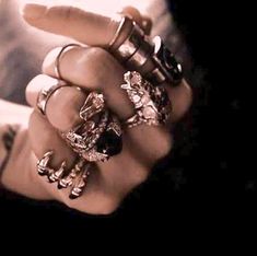 a woman with rings on her fingers in the dark