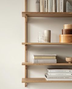 three wooden shelves with books and cups on them