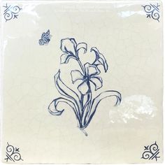 a blue and white plate with flowers on the side, in front of a butterfly