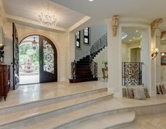 a large foyer with stairs leading up to the second floor and an entry door that leads to another room