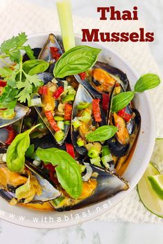 a bowl filled with steamed mussels and garnished with green leaves on top