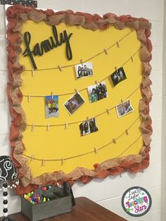 a bulletin board with family pictures and magnets attached to it on a school wall