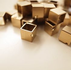 many small gold objects are scattered on the table top, including one square and two smaller ones