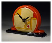 an orange and yellow clock sitting on top of a table