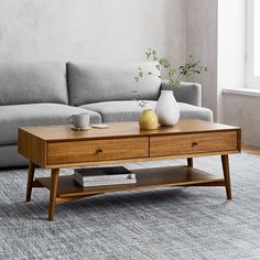 a living room with a couch, coffee table and vases on top of it