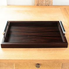 a wooden tray sitting on top of a table next to a pen and pencil holder