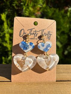 These Elegant Floral Beating Heart Earrings are a beautiful addition to any jewelry collection. Featuring two charming hearts with intricate floral detailing, these earrings are sure to catch your eye. The white background creates the perfect canvas for the periwinkle and gold color scheme, making these earrings perfect for any occasion. Crafted from high-quality resin and handmade with care, these artificial gemstone earrings have a unique and special feel. The double heart charms add an extra layer of elegance to this already stunning design. Whether you're dressing up for a special event or adding some sparkle to your everyday look, these Elegant Floral Beating Heart Earrings are sure to be a conversation starter. So why wait? Add them to your jewelry box today! Resin Gemstone Jewelry, White Double Heart Earrings For Gift, White Earrings With Heart Charm As Gift, White Hypoallergenic Heart Drop Earrings, Gold Heart-shaped Flower Earrings, White Dangle Resin Flower Earrings, White Double Heart Earrings With Heart Beads, White Resin Dangle Flower Earrings, White Flower Earrings For Valentine's Day