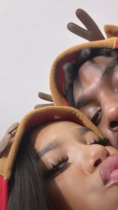 a man and woman are dressed up as reindeers with their noses close to each other