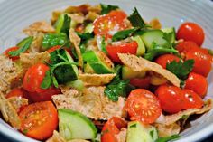 a white bowl filled with lots of vegetables and tortilla chips on top of it