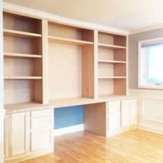 an empty room with wooden floors and built - in bookshelves