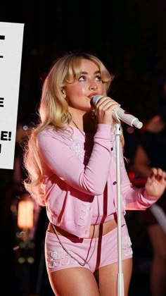 a woman in pink outfit holding a microphone