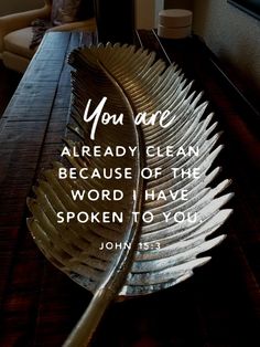 a spoon sitting on top of a wooden table next to a quote that reads, you are already clean because of the word i have spoken to you