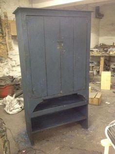 an old blue cabinet sitting in a garage