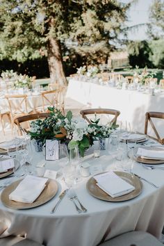 the table is set with plates and place settings