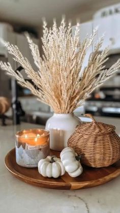 a tray with candles and some white pumpkins