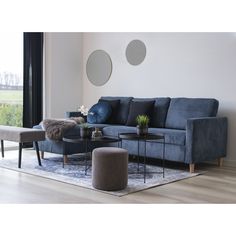 a living room with blue couches and round mirrors on the wall