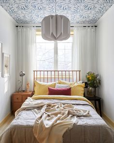 a bed sitting under a window in a bedroom