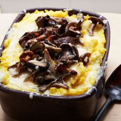 a brown bowl filled with mashed potatoes and mushrooms