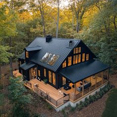 this is an aerial view of a house in the woods, with lots of windows