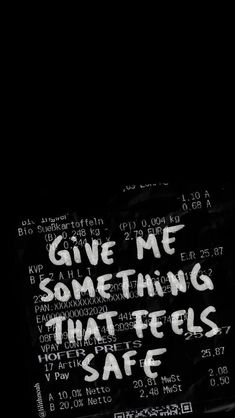 the words give me something that feels safe written in white ink on black paper with writing underneath